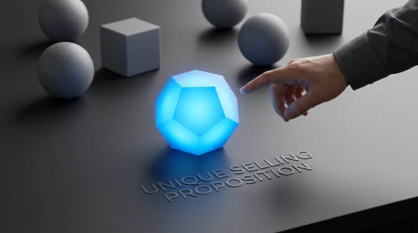 Une main touche un dodécaèdre bleu lumineux entouré de formes géométriques grises, avec le texte "UNIQUE SELLING PROPOSITION".